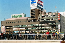 全壊した神戸新聞会館を横目に被災地を歩く人たち＝１９９５年１月２９日、神戸市中央区