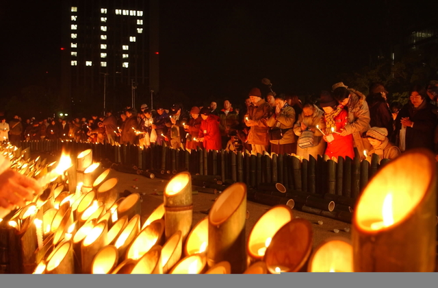 １１年前の夜明けに思いをはせ、ろうそくの灯に祈りをささげる。午前５時４６分、被災地は静寂に包まれた＝１７日、神戸市中央区、東遊園地（撮影・水田日出穂）
