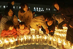 復興への願いを込めて開催された「１・１７　ＫＯＢＥに灯（あか）りを　ｉｎながた」。ろうそくに火をともす親子連れらの姿も目立った＝１７日午後６時３４分、神戸市長田区、ＪＲ新長田駅前（撮影・中西大二）
