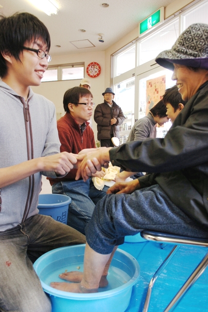 足湯サービスをする「中越・ＫＯＢＥ足湯隊」の鈴木孝典さん（左）ら＝兵庫県佐用町久崎