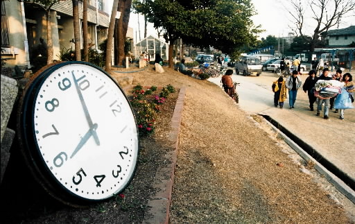 激震で発生時の時刻で止まり校庭の花壇に落下した大時計＝１９９５年１月１７日、神戸市東灘区魚崎中町、魚崎小学校