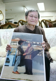 １３年前の写真を手に、震災を振り返る小谷さかゑさん＝神戸市灘区鶴甲５、新翠光園 