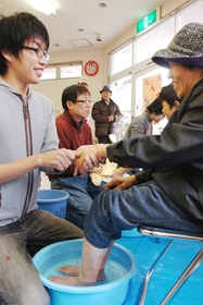 足湯サービスをする「中越・ＫＯＢＥ足湯隊」の鈴木孝典さん（左）ら＝兵庫県佐用町久崎