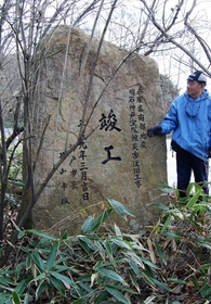 六甲山で崩落した岩で作られた震災モニュメント。県道復旧工事の竣工時期を刻む＝神戸市北区有馬町 