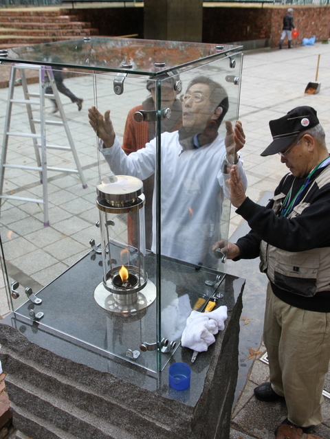 東遊園地のガス灯「１・１７希望の灯り」を清掃するＨＡＮＤＳのメンバー＝１６日、神戸市中央区加納町６