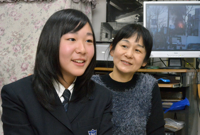 阪神・淡路大震災の写真や映像を見ながら、語り合う中井摩耶さん（左）と母の裕子さん＝西宮市南甲子園（撮影・笠原次郎）