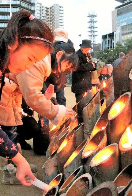 東遊園地の灯ろうに火をともす「くらぶ海音」の生徒ら＝神戸市中央区加納町６
