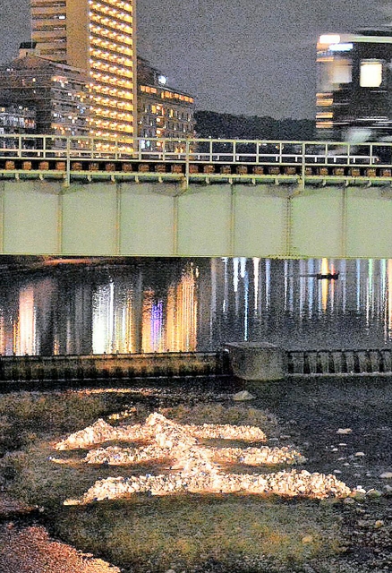 ライトアップされた武庫川中州の「生」＝16日午後６時４分、宝塚市内（撮影・笠原次郎）