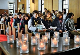 ろうそくがともされた礼拝堂で、１８年前の話を聞く学生たち＝９日午前、西宮市上ケ原一番町（撮影・笠原次郎）