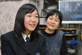 阪神・淡路大震災の写真や映像を見ながら、語り合う中井摩耶さん（左）と母の裕子さん＝西宮市南甲子園（撮影・笠原次郎）
