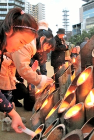 東遊園地の灯ろうに火をともす「くらぶ海音」の生徒ら＝神戸市中央区加納町６