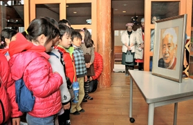 藤本義一さんの遺影を前に、黙とうをささげる子どもたち＝芦屋市浜風町、浜風の家
