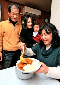 カレーをよそう母の原里美さん（右）。咲人ちゃんを抱く姉の木畑優紀絵さん、父の利昭さんも寄り添う＝１７日夜、神戸市東灘区御影中町７（撮影・峰大二郎）
