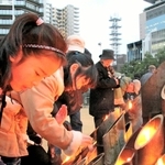 東遊園地の灯ろうに火をともす「くらぶ海音」の生徒ら＝神戸市中央区加納町６