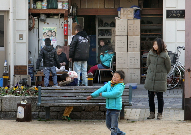 公園脇、谷川さん（左奥）のアクセサリー作りに子どもたちが集まる＝神戸市長田区本庄町３