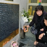 銘板に刻まれた保田幸子さんの遺影を手にする姉の柳田道子さん（左）と、次男の保田剛さん＝１７日午後、神戸市中央区加納町６（撮影・宮路博志）