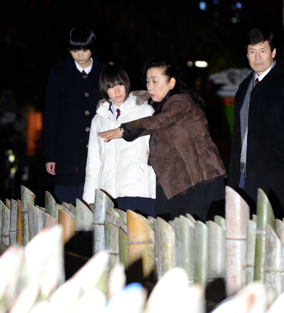 東遊園地の竹灯籠を見つめる（左から）森田礼子さん、及川真子さん、中嶋洋子さん、柏崎正明さん＝１６日夕、神戸市中央区加納町６（撮影・中西幸大）
