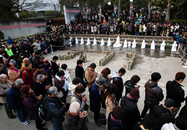 東日本大震災の被災地の方角に向かい、黙とうをささげる参列者＝１７日午後２時４６分、神戸市中央区加納町６（撮影・斎藤雅志）