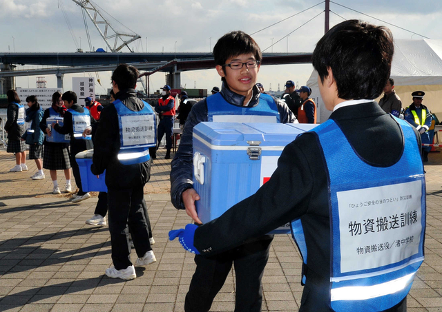 船で港に届けられた医療物資をリレーする訓練に取り組む中学生ら＝神戸市中央区脇浜海岸通１（撮影・宮路博志）