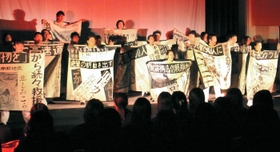 震災直後の新聞紙面を模した衣装で演じる生徒たち＝１１日、東京・国立オリンピック記念青少年総合センター