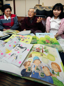 中條聖子さんが創作した「森のかんづめ」と、全国から届いたお礼状。（右から）姉鉃子さん、父秀信さん、母恵子さん＝大阪府寝屋川市（撮影・斎藤雅志）