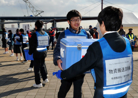 船で港に届けられた医療物資をリレーする訓練に取り組む中学生ら＝神戸市中央区脇浜海岸通１（撮影・宮路博志）