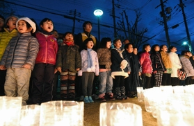 「しあわせはこべるように」を合唱する子どもたち＝１７日午後５時４９分、神戸市長田区若松町１０、若松鷹取公園（撮影・山崎　竜）