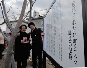 仮に張られた母の名前を見つめる宮崎久子さん（左）と孫の和史さん＝１９日午前、西宮市千歳町、千歳児童遊園（撮影・笠原次郎）
