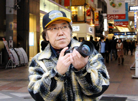 震災でアーケードが落ちた三宮センター街で、カメラを構える町田さん＝神戸市中央区三宮町１