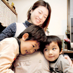 長男出海ちゃん（左）、次男理央ちゃんと一緒に、おなかの中の第３子に話し掛ける富田めぐみさん＝西宮市西波止町