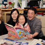 子どもたちと瞳ちゃんのアルバムをめくる竹場満さん（右から２人目）。「めっちゃかわいいやん」という声に思わず笑みがこぼれた＝神戸市灘区千旦通１（撮影・中西幸大）