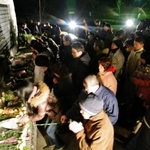 犠牲者の名前を刻んだ碑に献花する人たち＝１７日午前５時４８分、西宮市奥畑、西宮震災記念碑公園