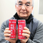 缶入り保存食「三穀食」を手にするミツレフーズの三宅利巨社長＝神戸市中央区海岸通４
