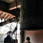犠牲者を追悼し、鐘を鳴らす国本行信住職（左）と桂子さん＝常隆寺