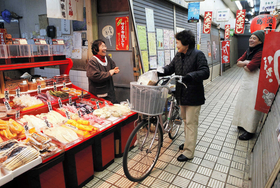 シャッターが並ぶ中で営業する漬物店。常連客と顔の見える関係が市場の強みだ＝神戸市長田区二葉町３、丸五市場（撮影・吉田敦史）