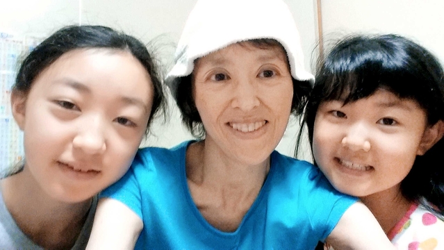 娘２人と笑顔を見せる光山由子さん