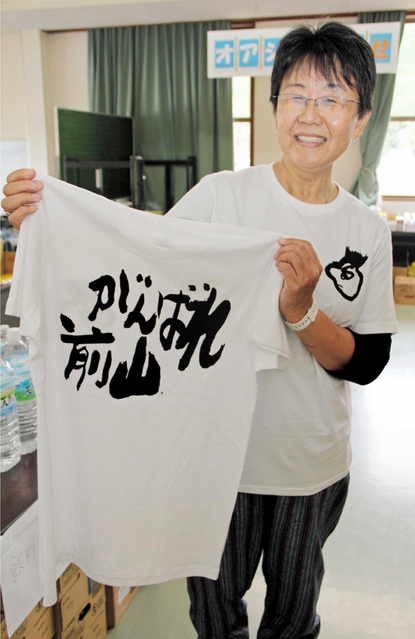 完成した「がんばれ前山」Ｔシャツを掲げる北村久美子さん＝丹波市市島町上竹田