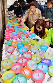 追悼のろうそく作りをするボランティア＝２５日午前、神戸市灘区摩耶埠頭（撮影・後藤亮平）