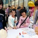 ワークショップに参加した子どもに、非常持ち出し袋の中身を選んでもらう大学生＝神戸市中央区東川崎町１