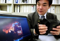 現在は企業誘致推進室で勤務する松崎さん。当時のビデオカメラと映像＝神戸市役所