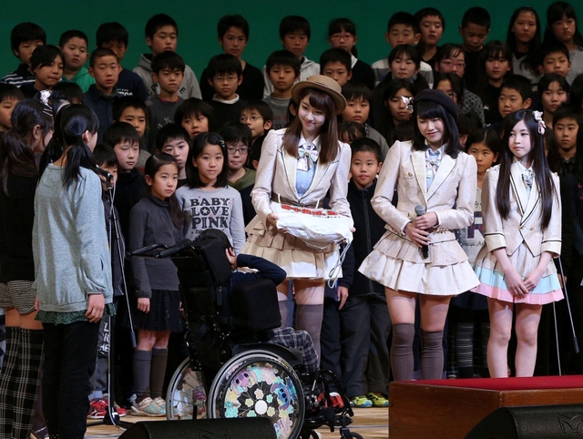 防災イベントでなぎさ小の児童にプレゼントを渡すＡＫＢ４８の柏木由紀さん（左）や横山由依さん（中央）ら＝１５日午後、神戸国際会館（撮影・峰大二郎）