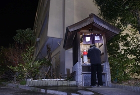 「福幸地蔵」。正月を前に、浜岡克代さんはほこらを拭き上げ、餅とミカンを供えた＝市営岩岡住宅（撮影・小林良多）