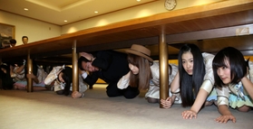 机の下に潜り込むＡＫＢ４８の柏木由紀さん（右から３人目）や久元喜造市長＝神戸市役所（撮影・峰大二郎）