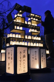 ろうそくと灯ろうに照らされたモニュメント「生」＝１６日夕、宝塚市南口２（撮影・笠原次郎）