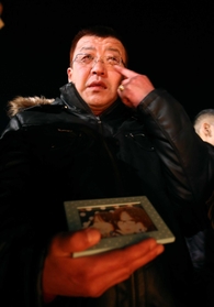 亡くなったななみさんの写真を手に、涙をぬぐう菊地篤也さん＝１７日午前６時５分、東遊園地（撮影・辰巳直之）