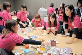 さまざまな非常食を手に、メニューを考える女子大学生ら＝２０１４年１１月１５日、神戸市役所