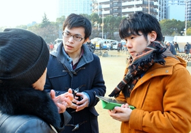 東遊園地でインタビューをする岡田さん（右）と広石さん＝１月１７日、神戸市中央区加納町６