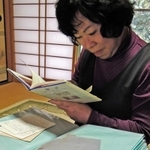 太祐さんへの思いをつづった詩集を読み返す野呂和美さん。香里さんからの手紙（手前）は今もファイルに収めている＝三重県松阪市飯高町