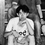 震災前年に「若葉荘」で下宿生らと写る野呂太祐さん。階段のそばに自室があった＝１９９４年７月、西宮市上ケ原五番町（野呂和美さん提供）