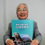 書店の被災記録を記した「阪神・淡路大震災　２０年の歩み」を持つ山根金造理事長＝神戸新聞社